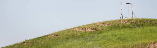 Holzschaukel Auf Grünem Hügel Unter Klarem Himmel Banner — Stockfoto