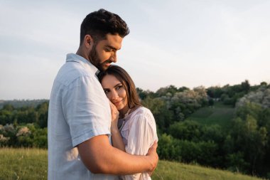 Mutlu çift yazın kırsalda kucaklaşıyor.