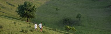 Uzaktan aile manzarası Kırsal kesimdeki yeşil tepelerde yürüyüş, pankart