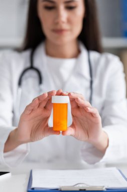 Klinikteki panonun yanında ilaç tutan bulanık doktor. 