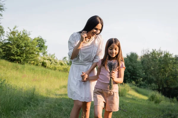 笑顔の娘とラベンダーの花束を手に田舎の幸せなお母さんと — ストック写真