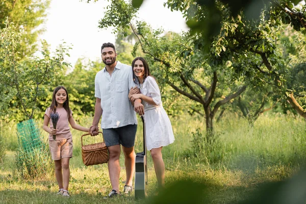 Joyful Family Wicker Basket Guitar Looking Camera Countryside Garden — Zdjęcie stockowe