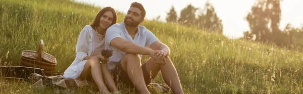 Pleased Couple Sitting Looking Away Meadow Countryside Banner — Zdjęcie stockowe