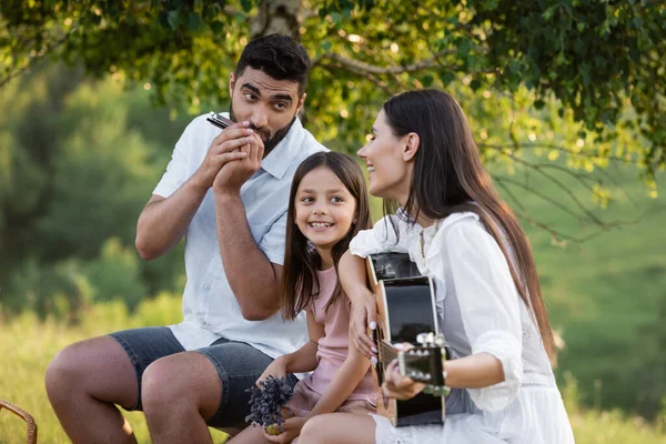 Felice Coppia Suonare Chitarra Armonica Vicino Allegra Figlia All Aperto — Foto Stock