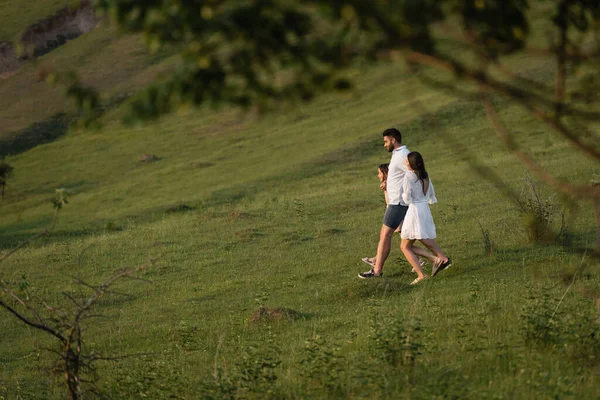 Side View Family Walking Green Field Blurred Foreground —  Fotos de Stock