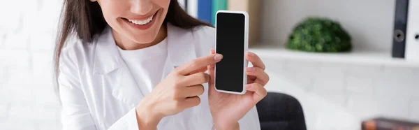 Vue Recadrée Médecin Souriant Pointant Vers Smartphone Avec Écran Blanc — Photo