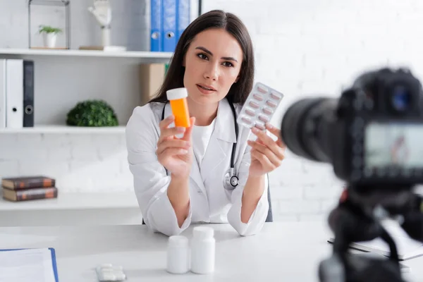 Médico Casaco Branco Segurando Pílulas Perto Câmera Digital Borrada Clínica — Fotografia de Stock