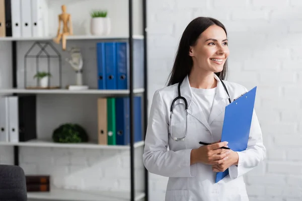 Médico Positivo Bata Blanca Sujetando Portapapeles Bolígrafo Clínica — Foto de Stock