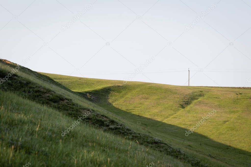 grassy slopes in countryside under clear cloudless sky