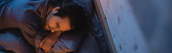 Κάτοψη Του Ανθρώπου Στην Πιτζάμα Ξαπλωμένος Στο Κρεβάτι Βράδυ Πανό — Φωτογραφία Αρχείου