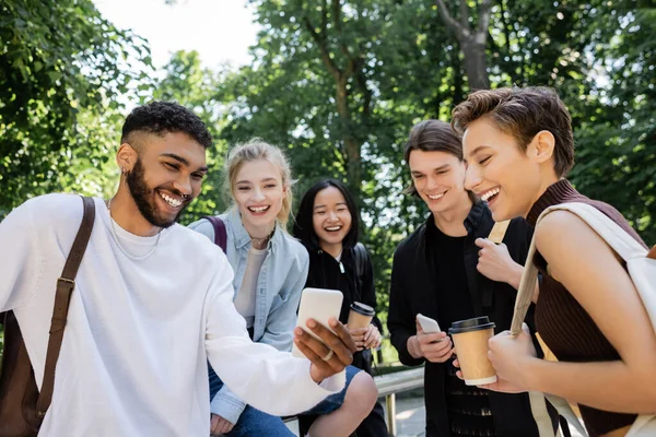 African American Student Holding Smartphone Interracial Friends Park — ストック写真