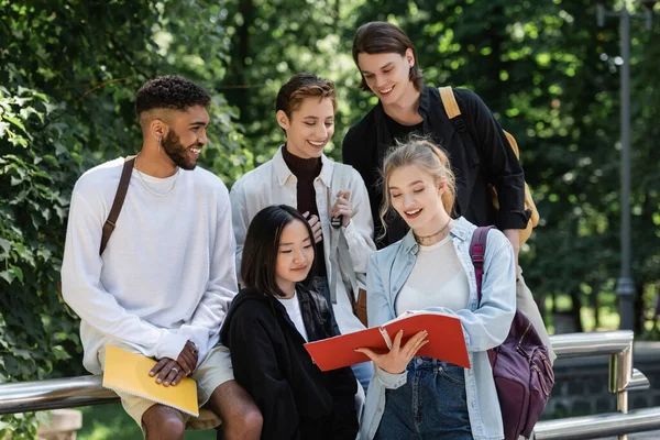 Cheerful Multiethnic Students Looking Notebook Park — Zdjęcie stockowe