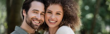portrait of cheerful young couple smiling and looking at camera, banner