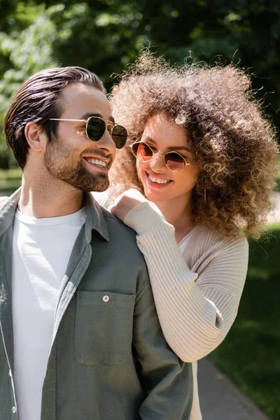 Pleased Woman Hugging Happy Man Stylish Sunglasses Park — 스톡 사진