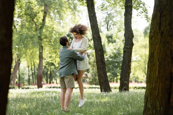 Full Length Young Man Lifting Happy Girlfriend Summer Dress Green — Stockfoto