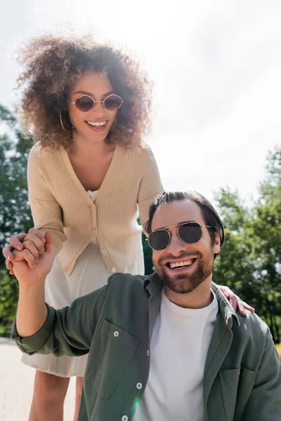 Cheerful Man Pleased Curly Woman Trendy Sunglasses Smiling Park — Stockfoto