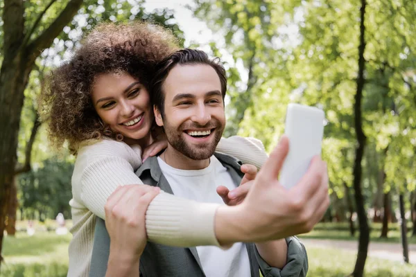 Ευτυχισμένο Ζευγάρι Που Παίρνουν Selfie Θολή Smartphone Στο Καλοκαιρινό Πάρκο — Φωτογραφία Αρχείου