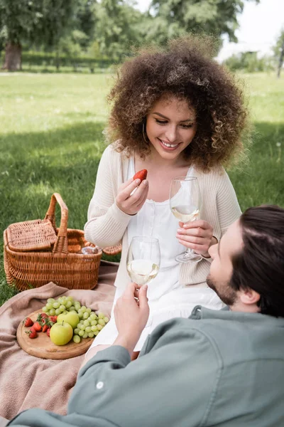 Happy Curly Woman Holding Strawberry Glass Wine Smiling Boyfriend Picnic —  Fotos de Stock