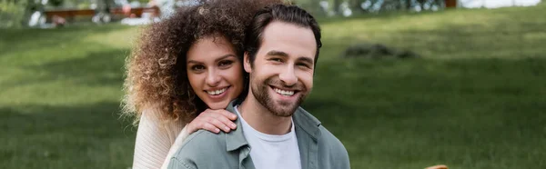 Hombre Alegre Sonriendo Con Mujer Rizada Mirando Cámara Pancarta —  Fotos de Stock