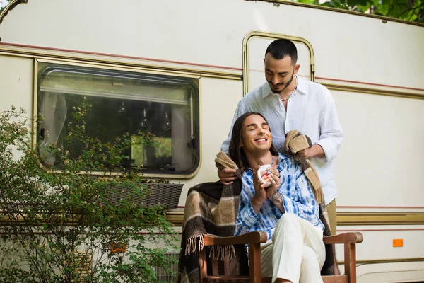 Caring Gay Man Holding Blanket Happy Boyfriend Cup Coffee Sitting — Stock Fotó