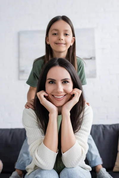 Happy Kid Looking Camera Smiling Babysitter Sitting Couch Living Room — Zdjęcie stockowe