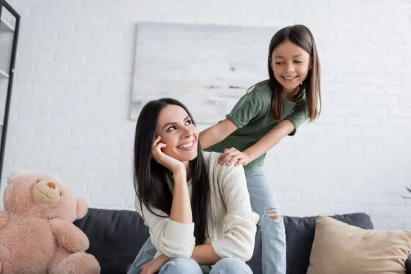 Playful Girl Standing Happy Babysitter Resting Couch Living Room — Zdjęcie stockowe