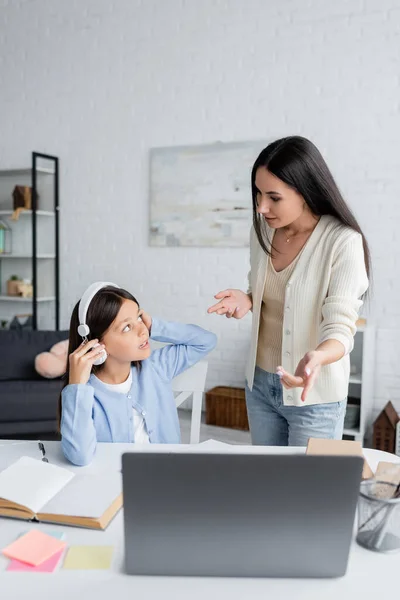 Niñera Apuntando Computadora Portátil Cerca Chica Sentada Los Auriculares Durante — Foto de Stock