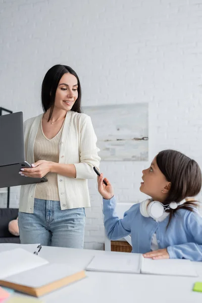 Ragazza Che Punta Con Penna Sorridente Tata Piedi Con Computer — Foto Stock