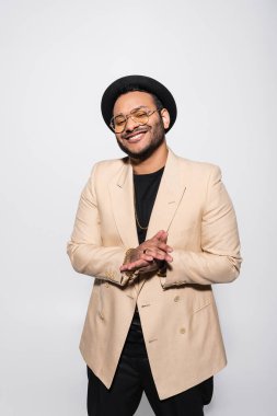 Fötr şapkalı ve gri gözlüklü mutlu Hintli hip hop sanatçısı. 