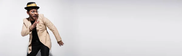 Восточный Хип Хоп Исполнитель Шляпе Очках Смотрящий Сторону Жестикулирующий Сером — стоковое фото