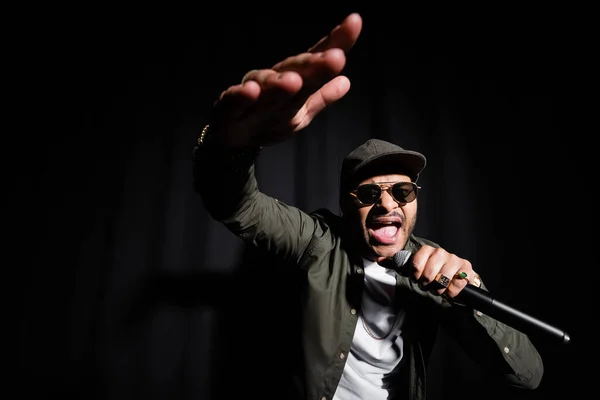 Emotional Indian Hip Hop Performer Raised Hand Singing Microphone Black — Stock Photo, Image