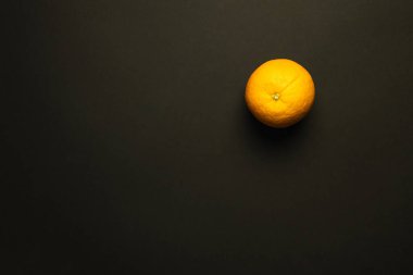 Top view of bright orange isolated on black  clipart