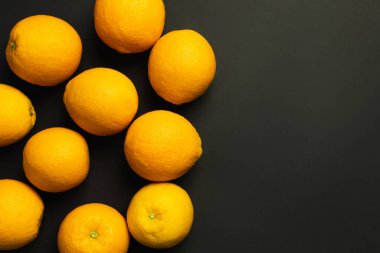 Top view of tasty and whole oranges isolated on black 