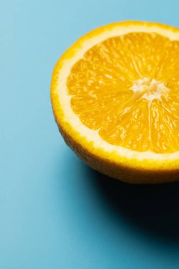 Close up view of juicy and cut orange on blue background