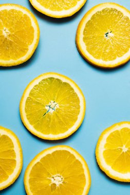 Mavi arkaplanda doğal portakal dilimlerinin üst görünümü