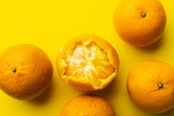 Top view of mandarins in peel on yellow background