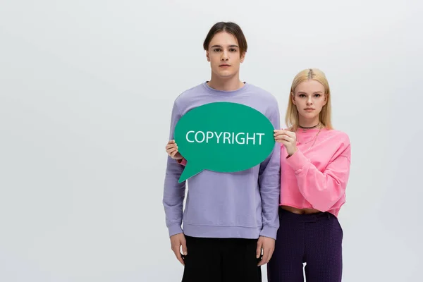 Young Woman Sweatshirt Holding Speech Bubble Copyright Lettering Isolated Grey — Stok fotoğraf