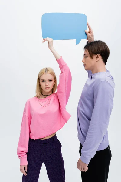 Young Man Holding Speech Bubble Looking Blonde Girlfriend Isolated Grey — Stockfoto