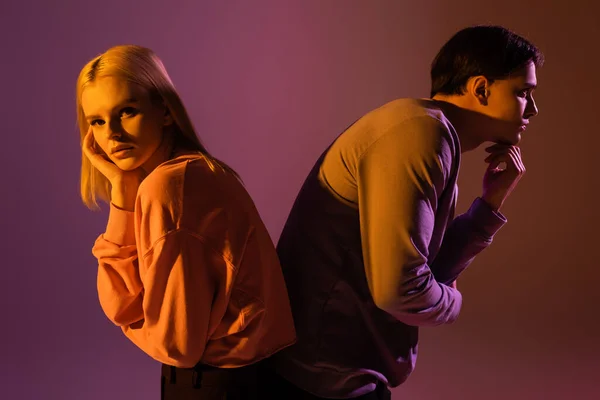 Young Stylish Couple Sweatshirts Posing Back Back Purple Background Lighting — Stock Photo, Image