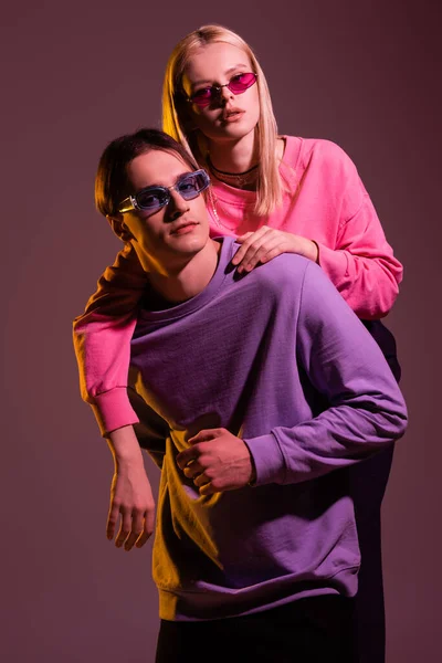 Trendy Woman Sunglasses Hugging Boyfriend Sweatshirt Isolated Purple Lighting — Fotografia de Stock