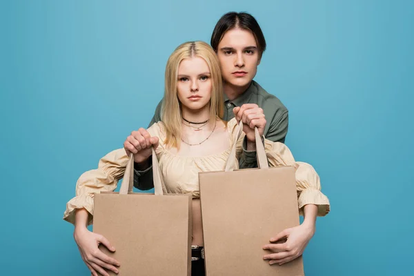 Young Trendy Couple Posing Purchases Isolated Blue —  Fotos de Stock