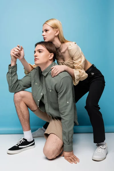 Pretty Blonde Woman Hugging Stylish Boyfriend While Posing Blue Background — Stok fotoğraf