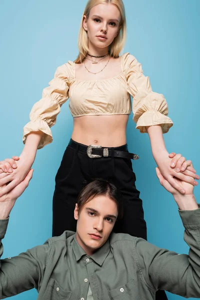 Trendy Couple Holding Hands Looking Camera Isolated Blue — Stockfoto