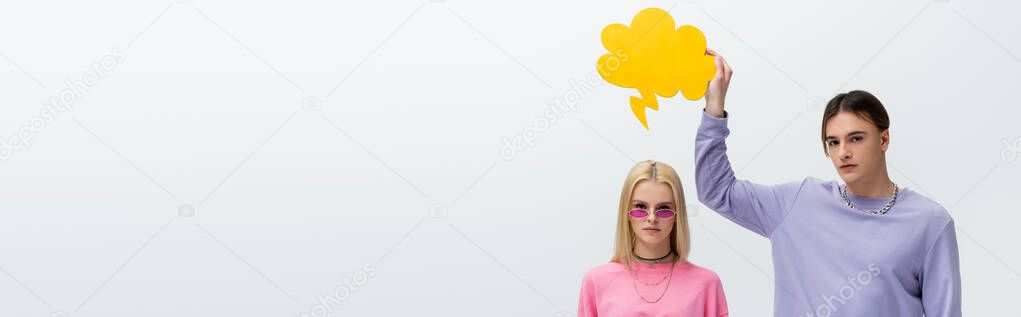 Stylish man holding thought bubble above girlfriend in sunglasses isolated on grey, banner 