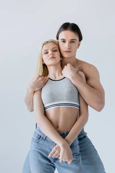 Muscular Man Hugging Pretty Girlfriend Top Jeans Isolated Grey — Zdjęcie stockowe