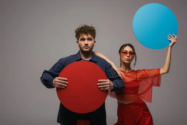 Modelos Elegantes Roupas Azuis Vermelhas Moda Segurando Caixa Forma Redonda — Fotografia de Stock