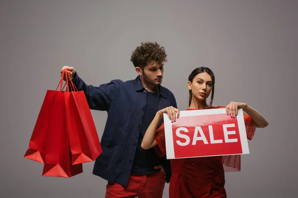 Couple Trendy Outfits Holding Shopping Bags Paper Sale Lettering Isolated — Photo