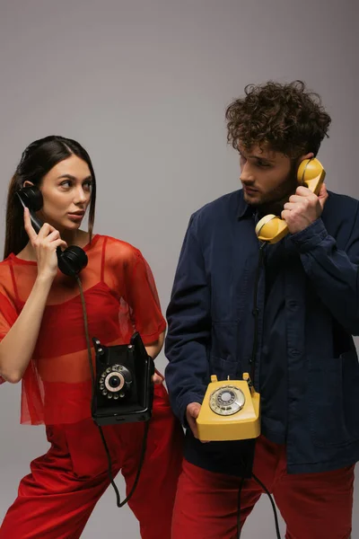 Mulher Moda Homem Encaracolado Segurando Aparelhos Retro Telefones Isolados Cinza — Fotografia de Stock