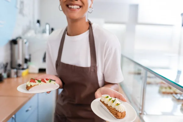 Cropped View Eclair Hand Blurred African American Seller Sweet Shop — Photo