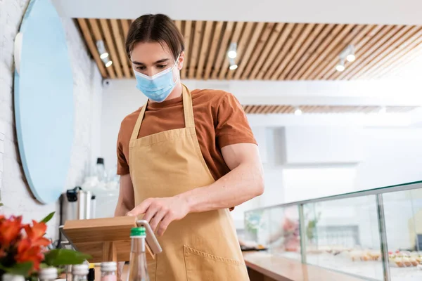 Young Salesman Medical Mask Using Digital Tablet Sweet Shop — Stock Photo, Image